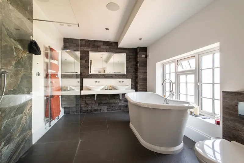 Bathroom with freestanding bath, stone feature wall and double basins