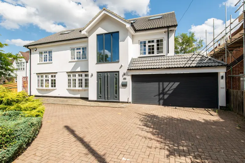 Front of a detached house with fresh render and a new garage door